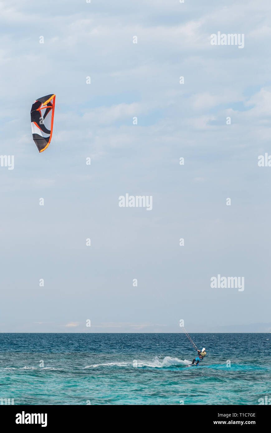 Professionelle kiter die Wasseroberfläche im Ozean mit großer Geschwindigkeit gleiten. Zurück hinter extreme Totale anzeigen Stockfoto
