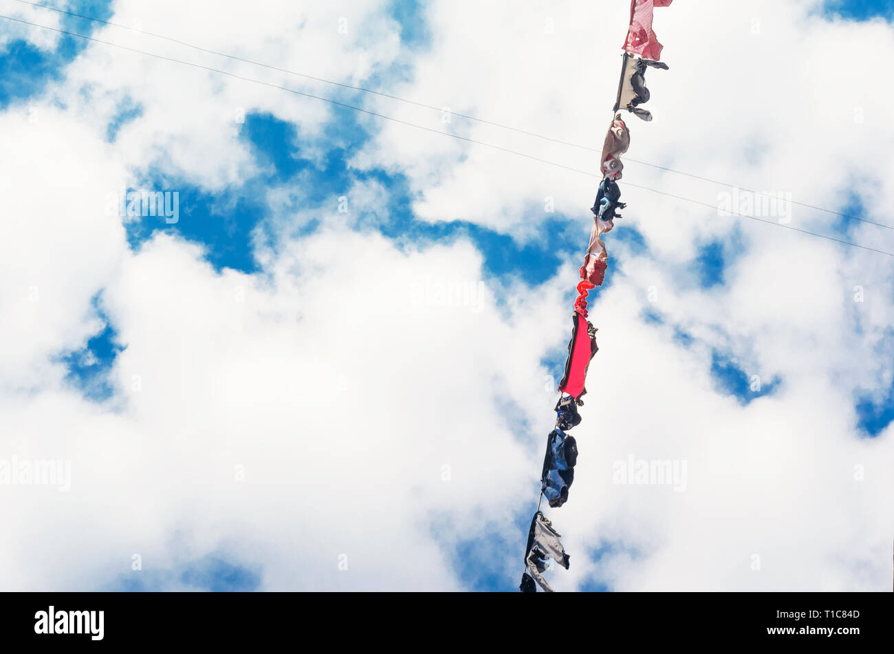 Die Bettwäsche ist auf der Wäscheleine auf dem Hintergrund der blauen Himmel mit Wolken getrocknet. Sonnigen Tag Stockfoto