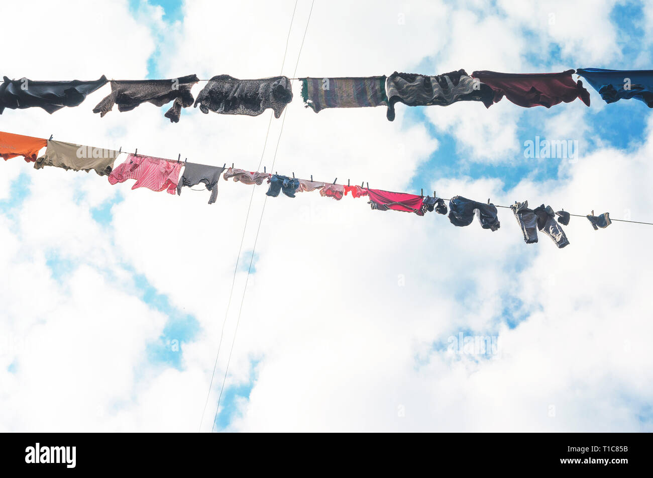 Die Bettwäsche ist auf der Wäscheleine auf dem Hintergrund der blauen Himmel mit Wolken getrocknet. Sonnigen Tag Stockfoto