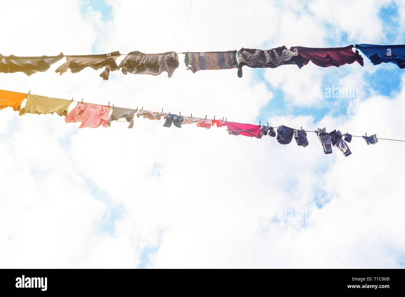Die Bettwäsche ist auf der Wäscheleine auf dem Hintergrund der blauen Himmel mit Wolken getrocknet. Sonnigen Tag Stockfoto