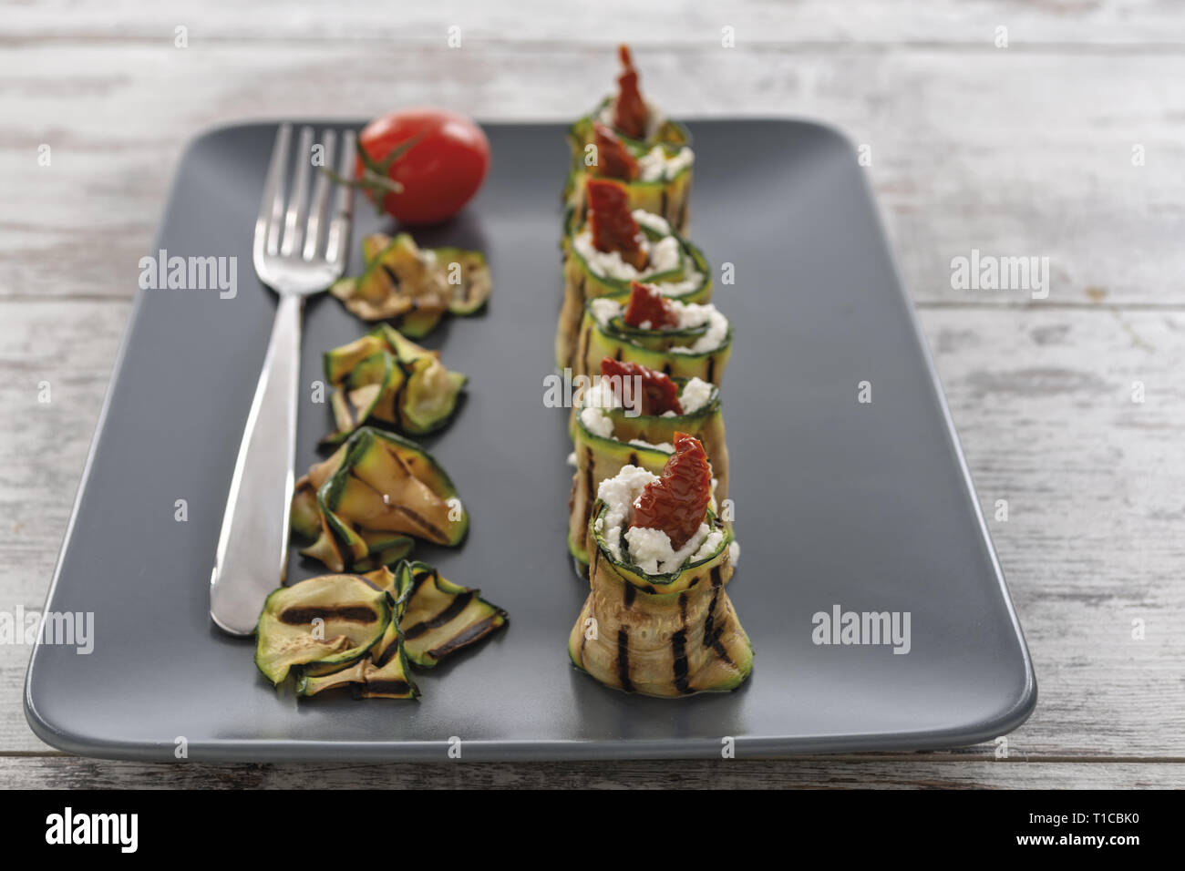 Zucchine grigliate arrotolate con Ricotta e Pomodoro secco Piatto verticale da Sopra Stockfoto