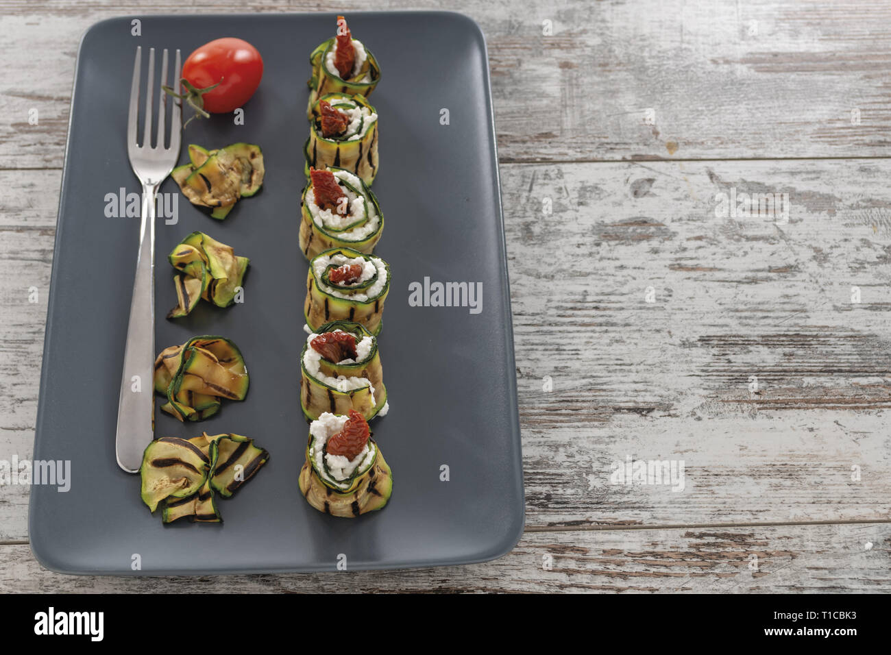 Zucchine grigliate arrotolate con Ricotta e Pomodoro secco Piatto verticale Dall-alto Stockfoto