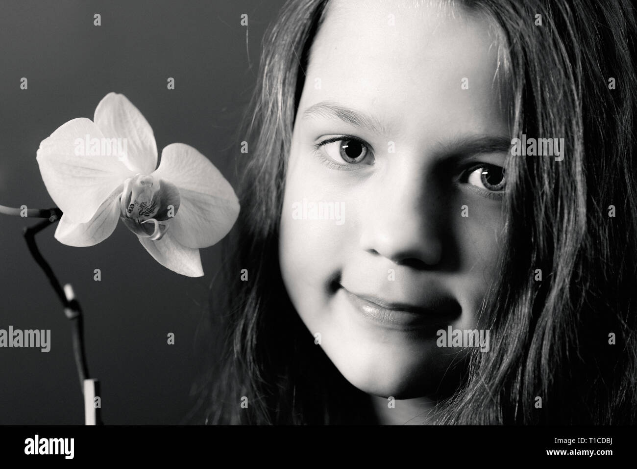 Monochrome Portrait von Kind Mädchen mit White Orchid Stockfoto