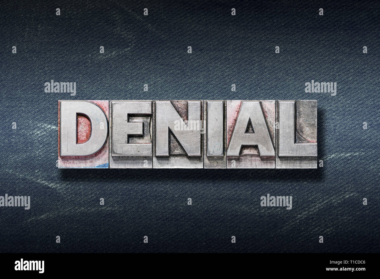 Denial-Wort von metallischen Buchdruck auf dunklen Jeans Hintergrund Stockfoto