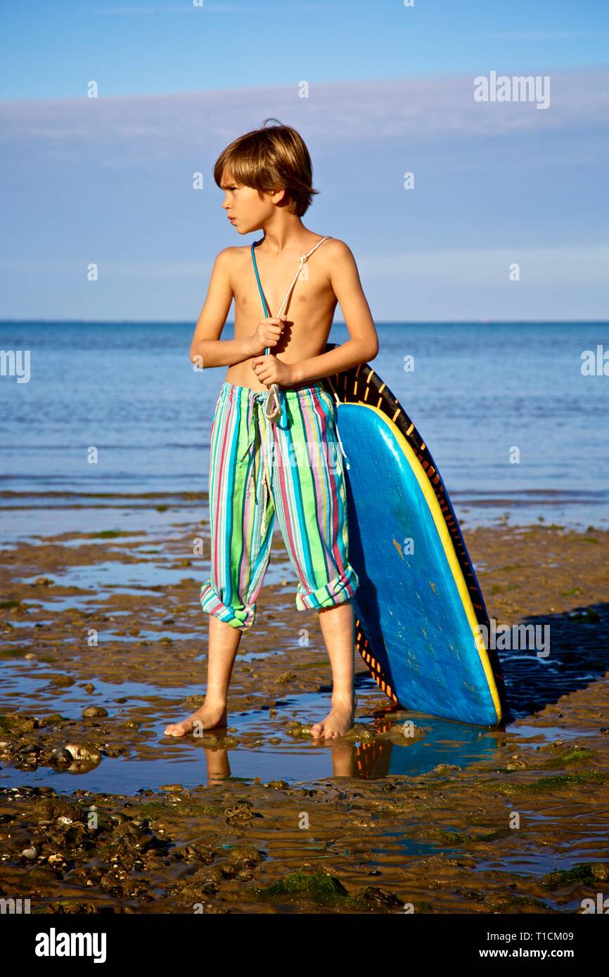Gutaussehenden jungen 8-10 Jahre alter Junge zieht ein BODYBOARD am Strand Stockfoto