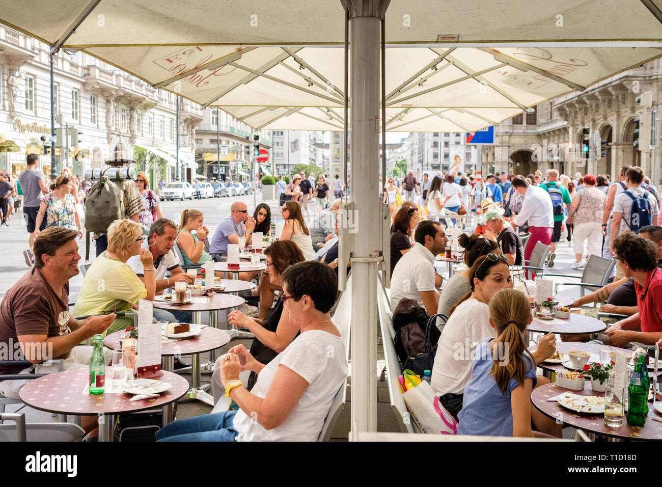 Menschen essen Sachertorte im Freien im Hotel Sacher an einem Sommertag in Wien, Österreich. Stockfoto