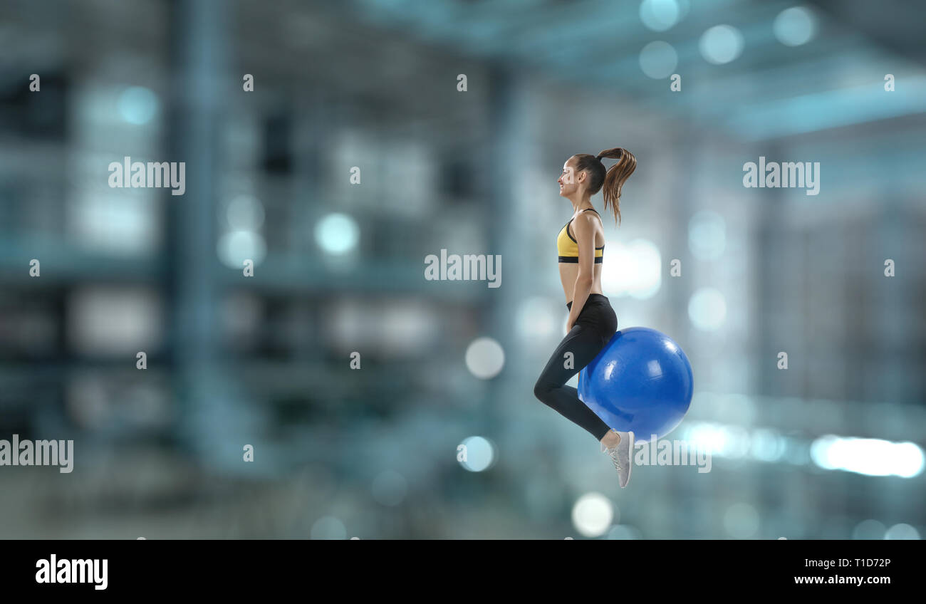 Sportliche Frau auf Fitness Ball. Mixed Media Stockfoto