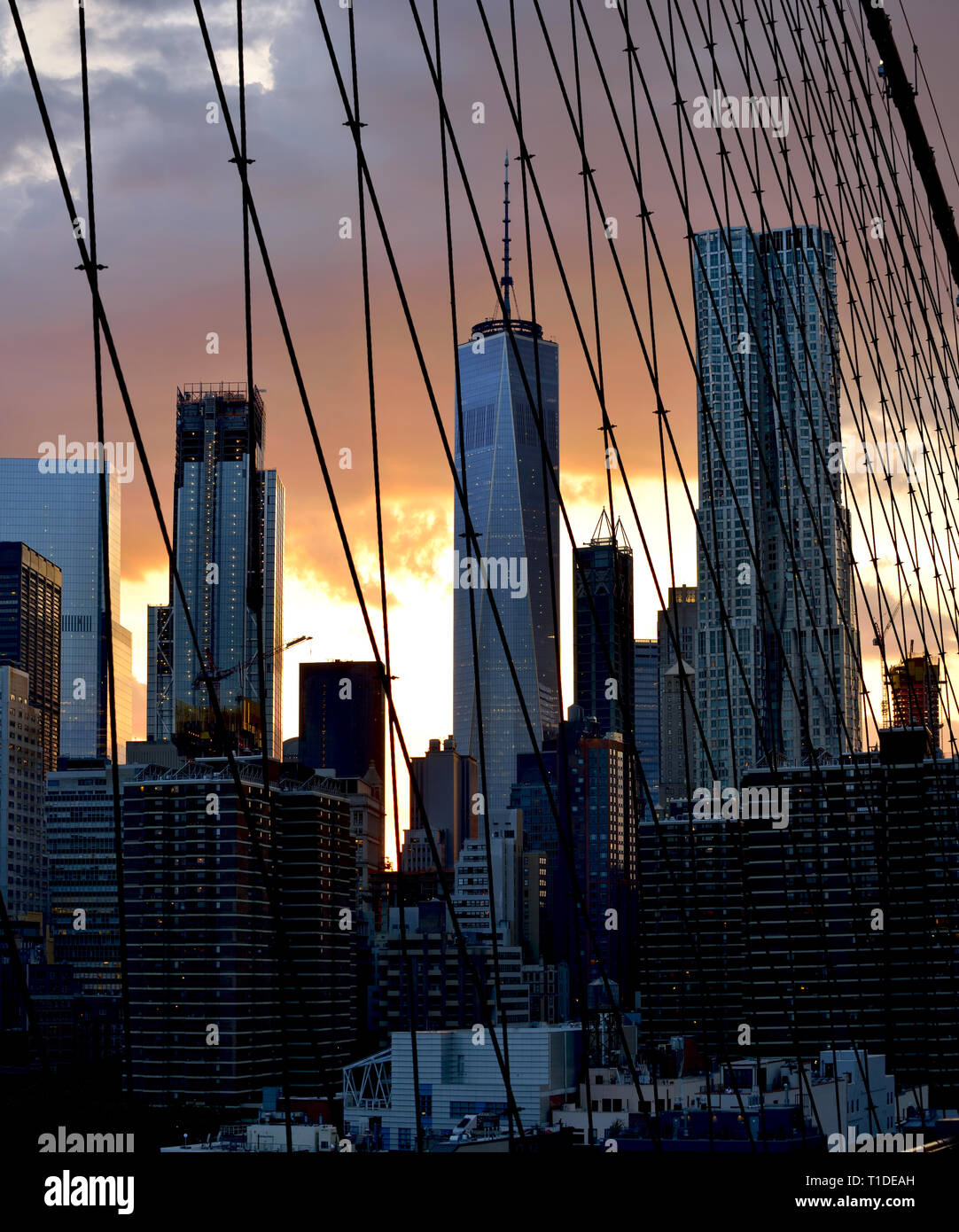 New York City Twilight. Blick auf Lower Manhattan durch Brooklyn Brücke Tragseile. Zusammenfassung Hintergrund. Stockfoto