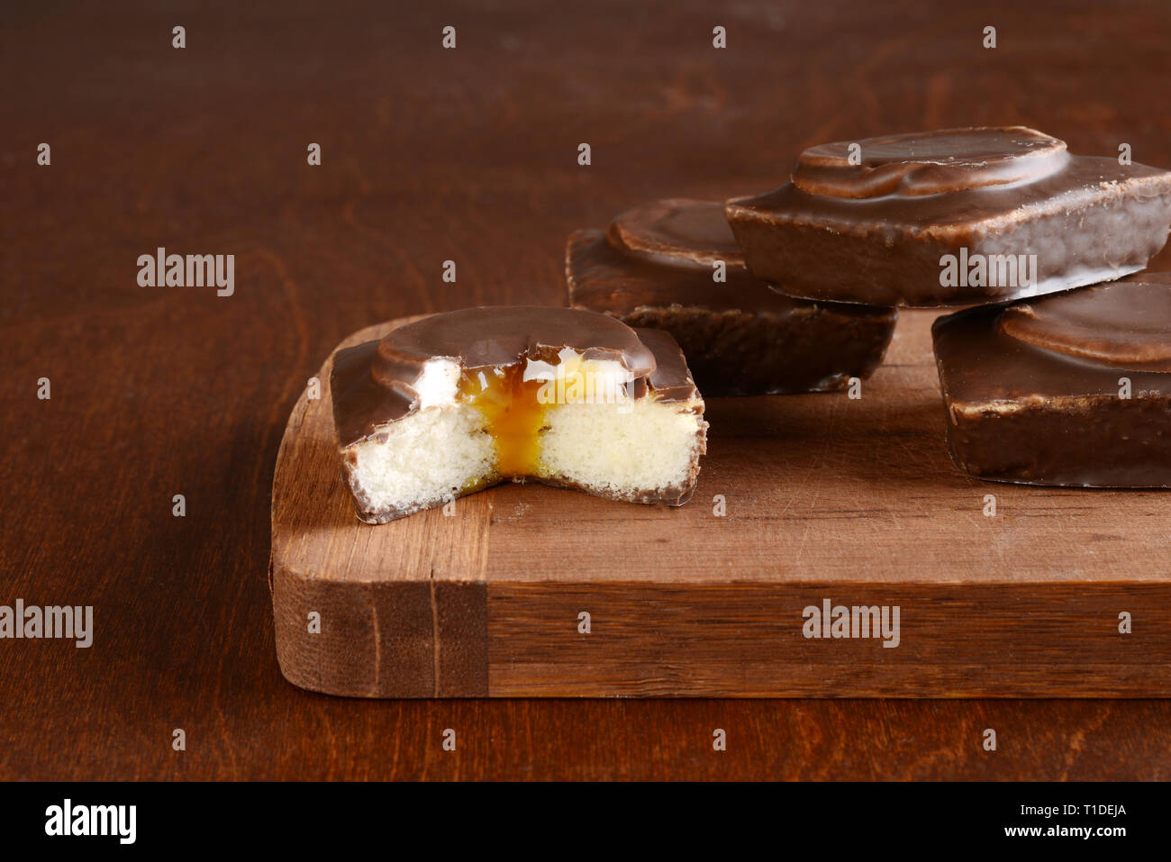 Schneiden Sie kleine Schokolade Vanille Kuchen mit Sahne und Karamell Sauce gefüllt Stockfoto