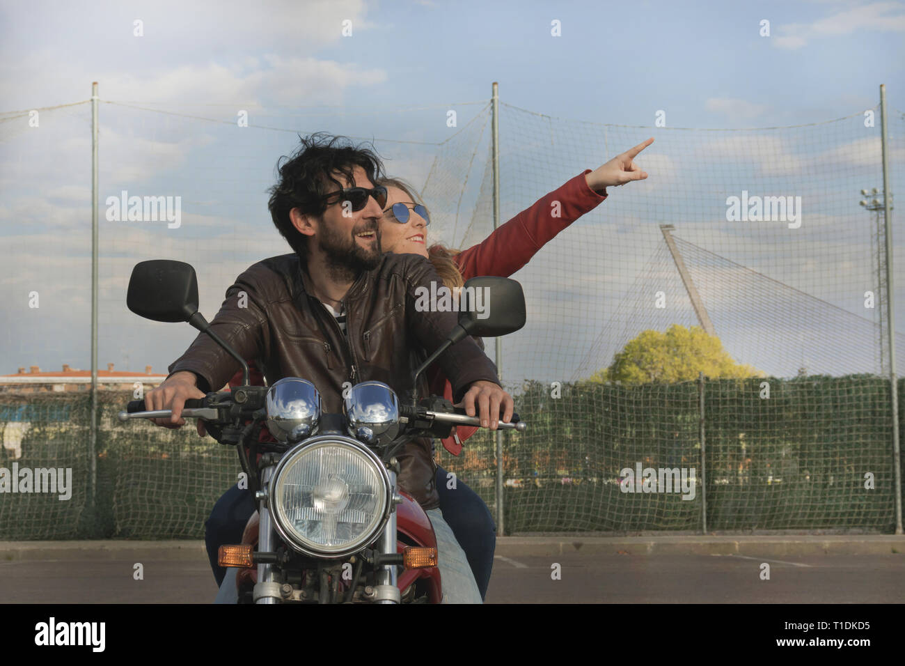 Paar Motorradfahrer auf einem Retro Stil Motorrad, mit Blick auf den blauen Himmel. Frau zeigt mit ihrem Arm in den Himmel in Spanien Stockfoto