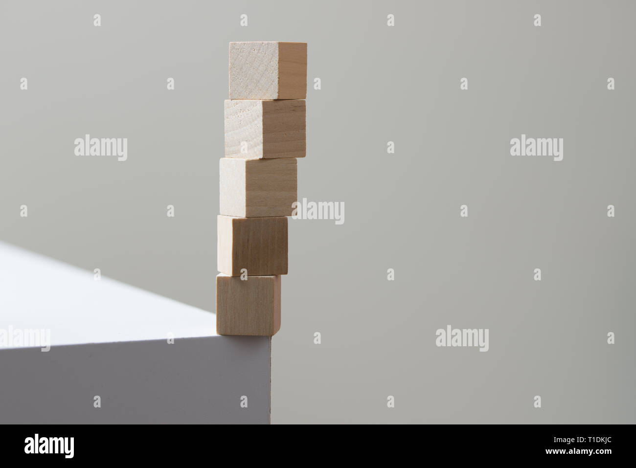 Holzwürfel in Balance am Rand der Tabelle für Risiko Konzept Stockfoto