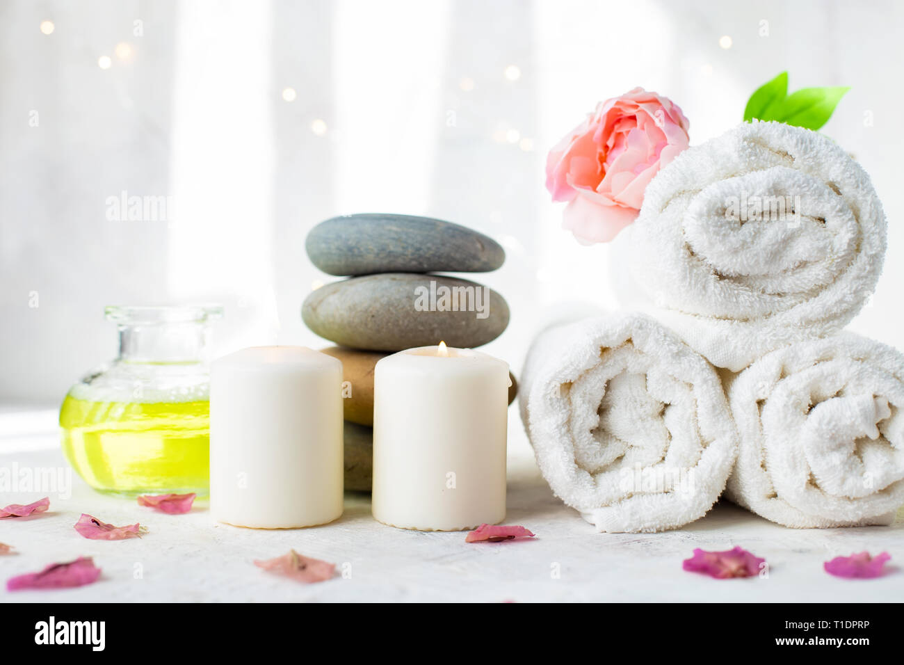 Wellness, Beauty und Wellness Hintergrund Handtuch Kosmetik Massage Öl,  Blumen und brennende Candel, warmen Massage Steine Stockfotografie - Alamy