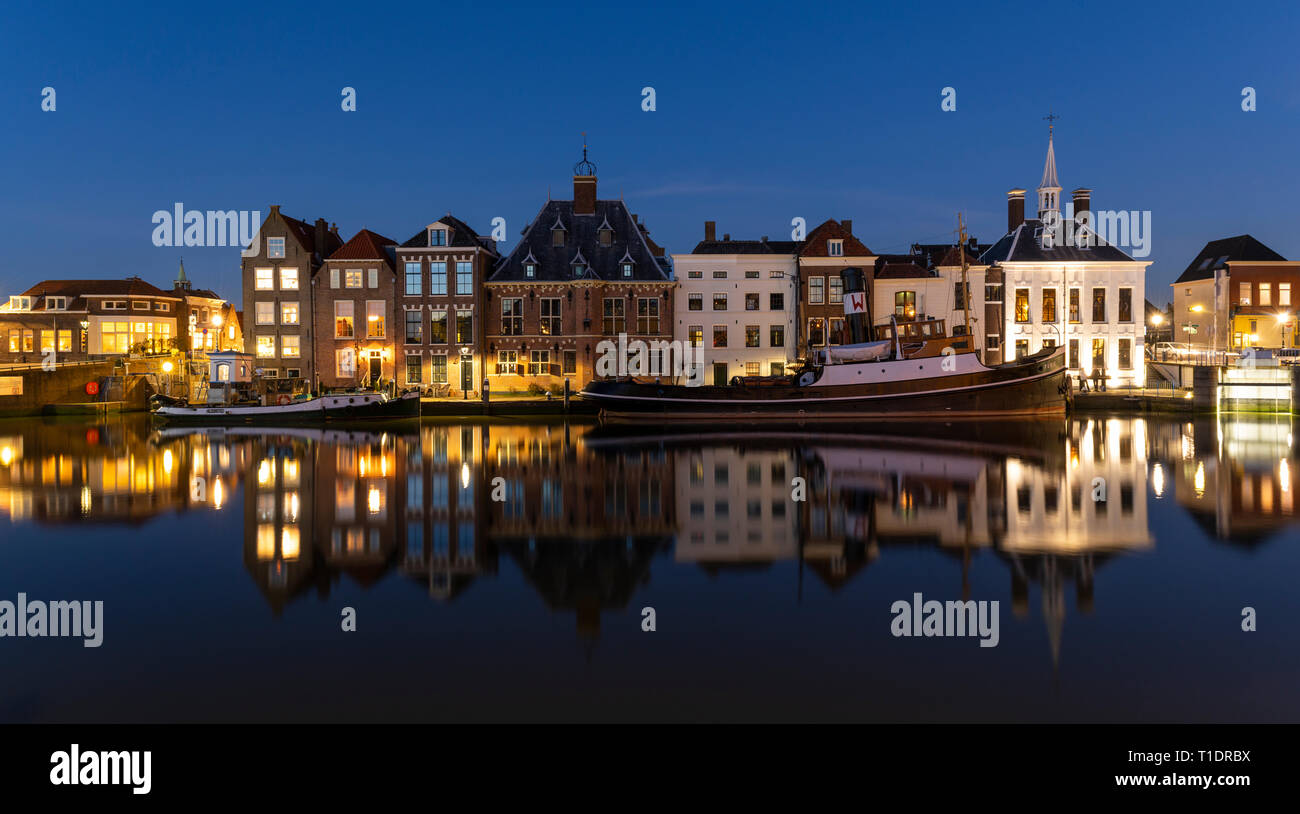 Maassluis, Niederlande - 26. Februar 2019: Der Hafen von Maassluis mit alten Boote, Schlepper und monumentale Häuser in der Nacht. Stockfoto