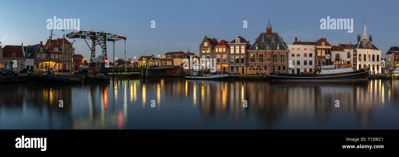 Maassluis, Niederlande - 26. Februar 2019: Panorama auf den Hafen von Maassluis mit alten Boote, Schlepper und monumentale Häuser in der Nacht. Stockfoto