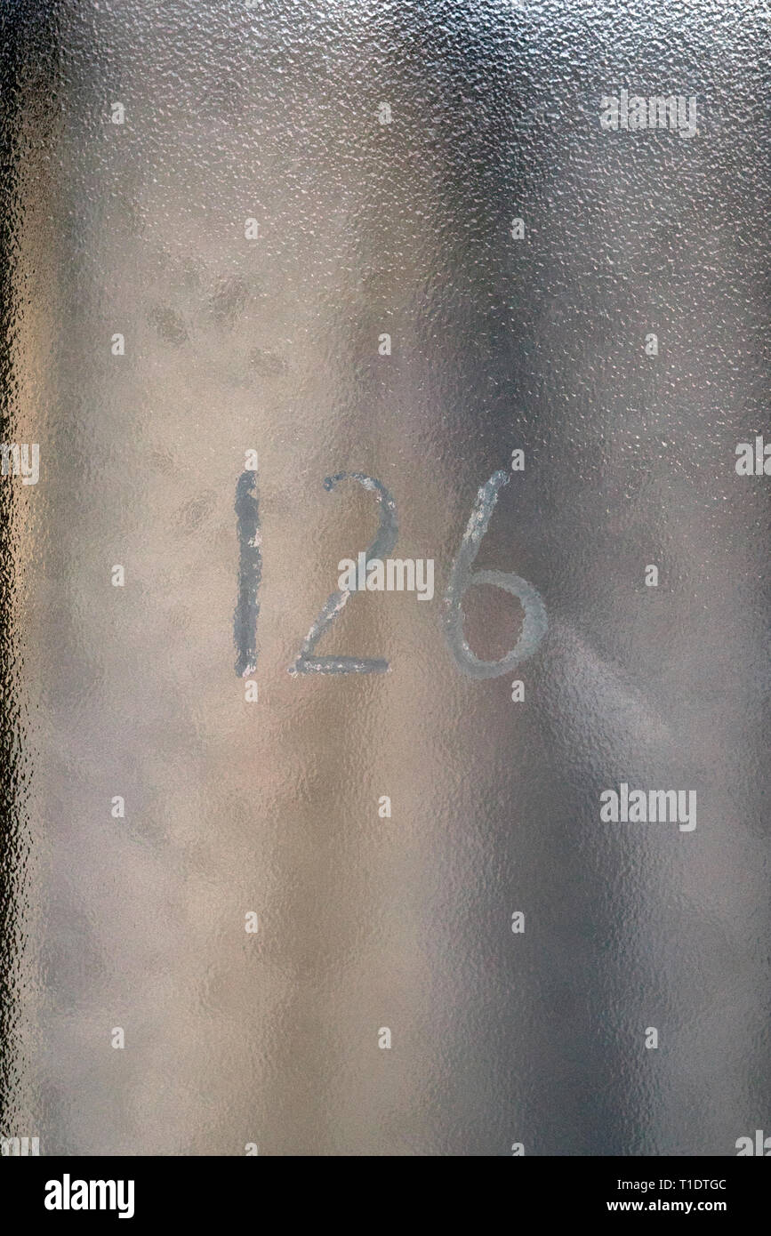 Die Zahl Einhundert und Zwanzig sechs Hand gemalt auf ein Glas Türblatt Stockfoto