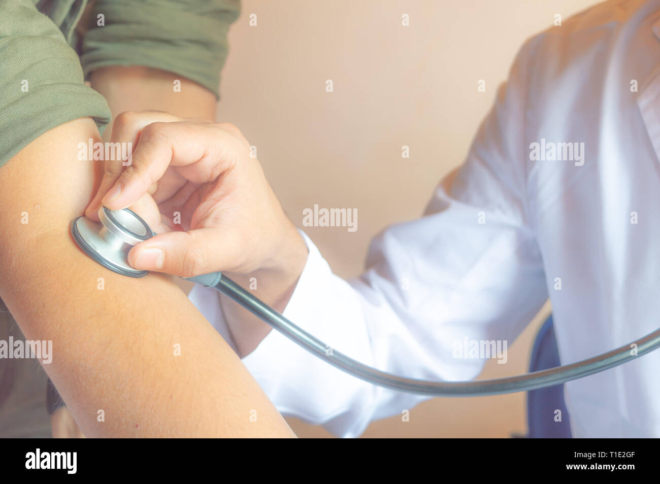 Ein Arzt Kontrolle der Blutdruck und Puls eines Patienten Stockfoto