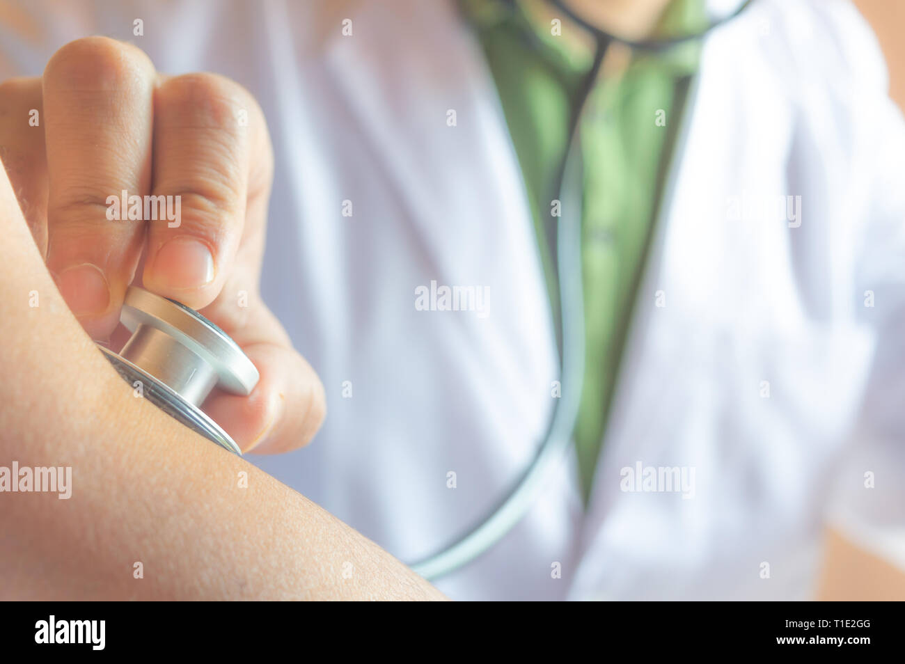 Ein Arzt prüfen der Puls eines Patienten mit seinem Stethoskop Stockfoto