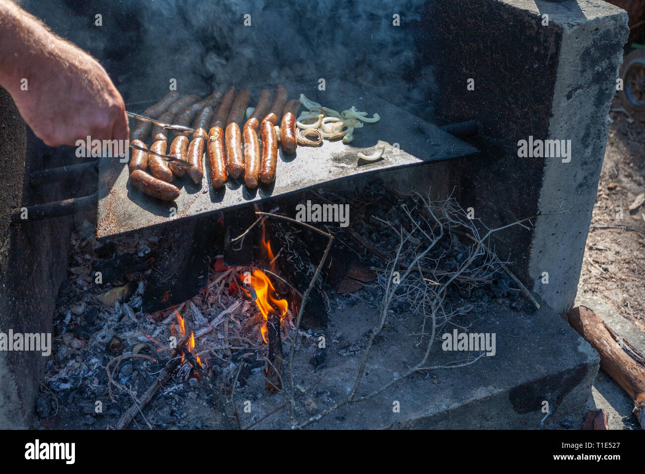 Wurst und Zwiebeln Kochen über einem Feuer Grill in Australien Stockfoto