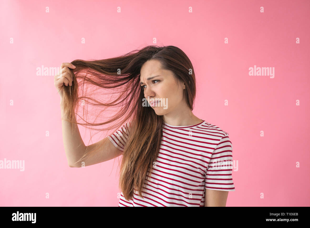 Das Mädchen ist nicht glücklich mit ihrem Haar und Spliss oder Schuppen oder trockenes Haar oder andere Probleme. Stockfoto