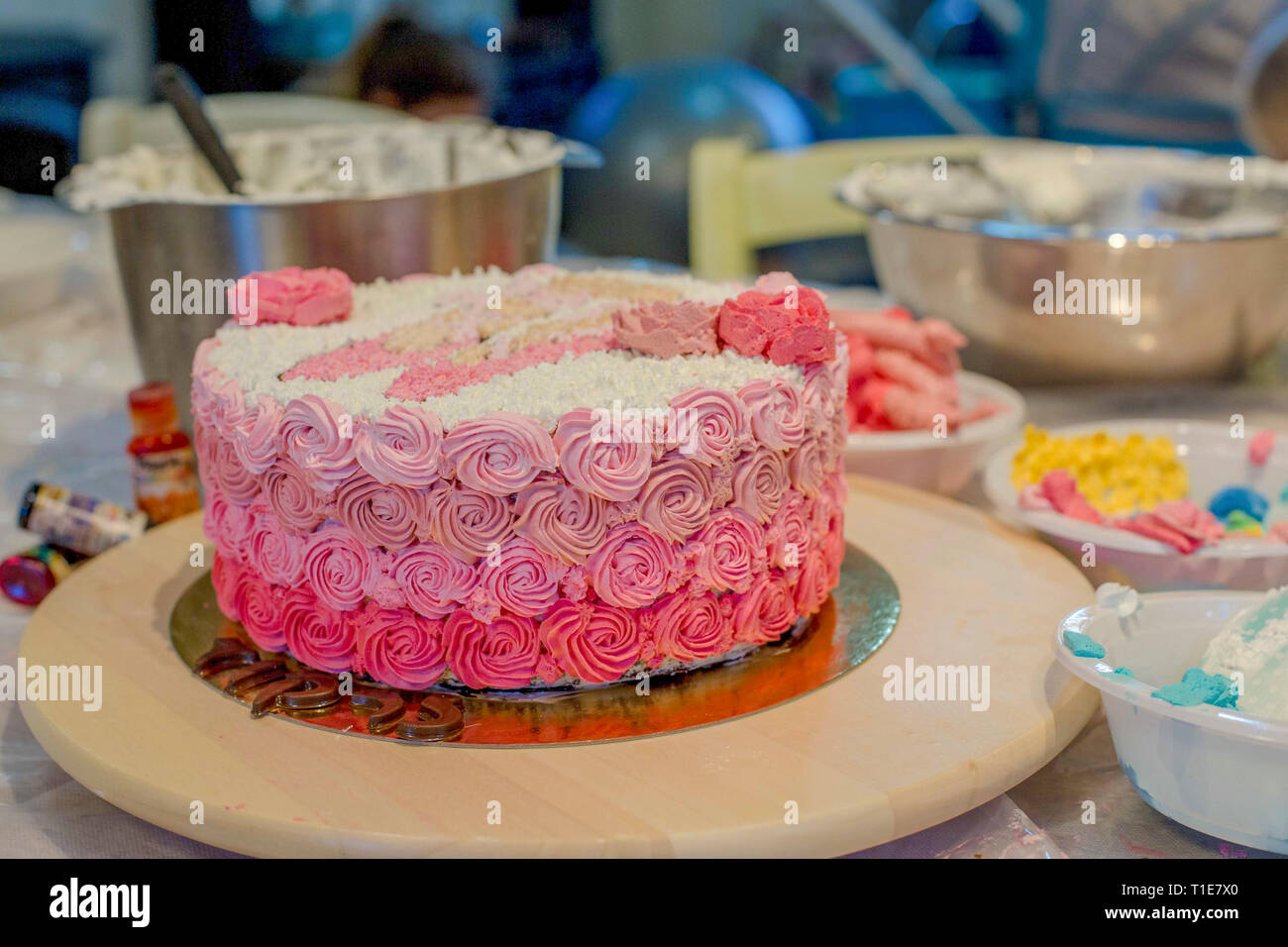 Die Verzierung eines Geburtstag Kuchen mit Puderzucker Einhorn Stockfoto