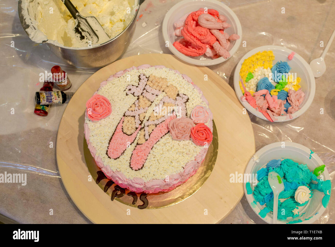 Die Verzierung eines Geburtstag Kuchen mit Puderzucker Ballett Schuhe, Stockfoto