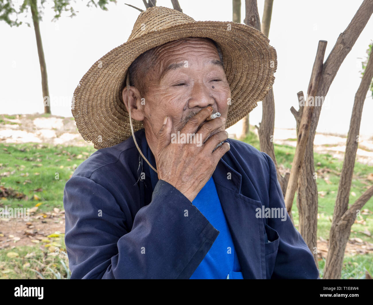 Porträt eines lokalen reifer Mann Rauchen in einem kleinen Dorf in den Bergen in der Nähe von Kumming, Provinz Yunnan im Südwesten Chinas im September Stockfoto