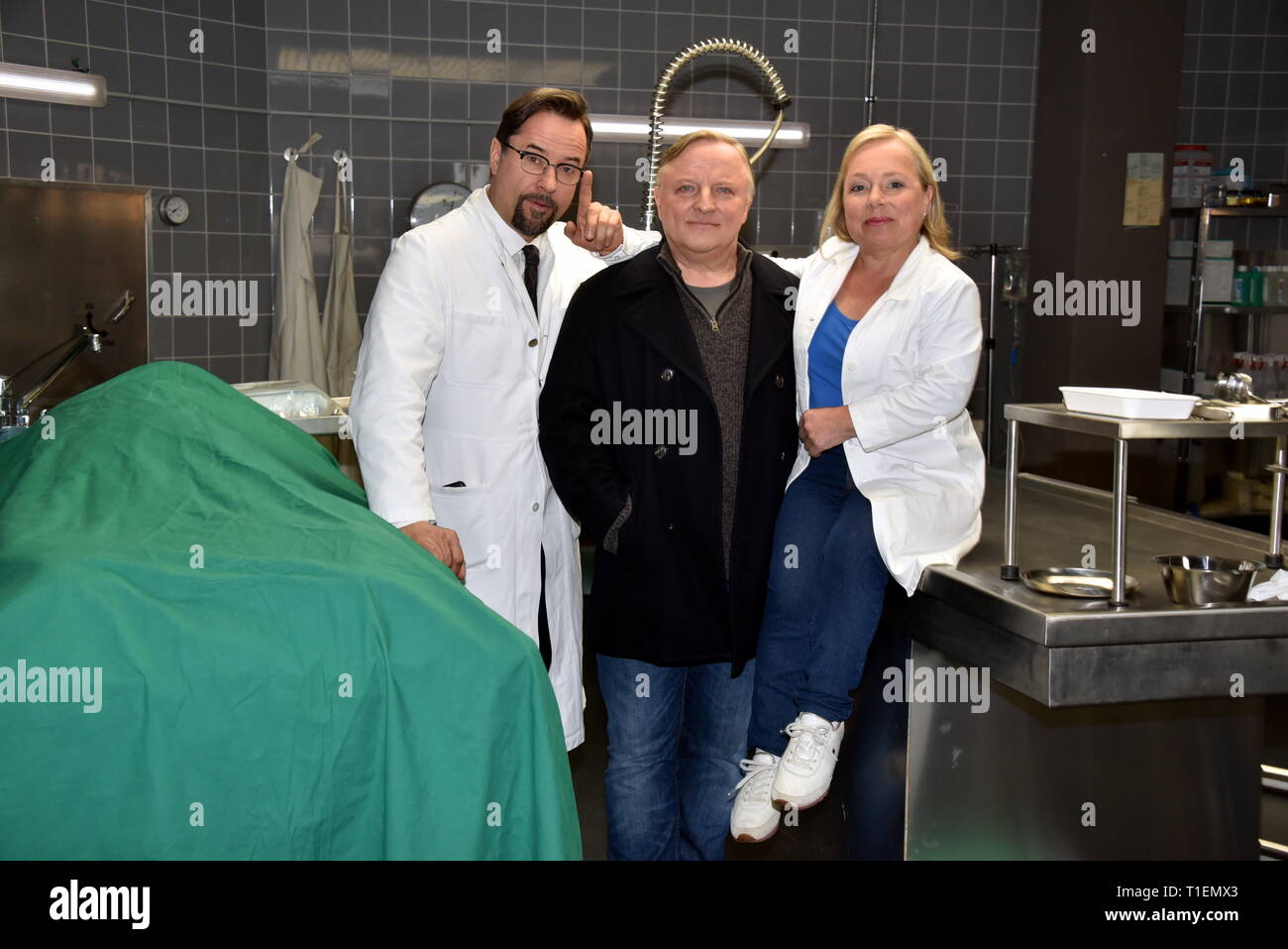 26. März 2019, Nordrhein-Westfalen, Köln: Die Schauspieler Jan Josef Liefers (L-R), Axel Prahl und Christine Urspruch stand in der Landschaft der gerichtlichen Medizin beim Fototermin am "Tatort Münster - Lakritz" (AT). Foto: Horst Galuschka/dpa Stockfoto