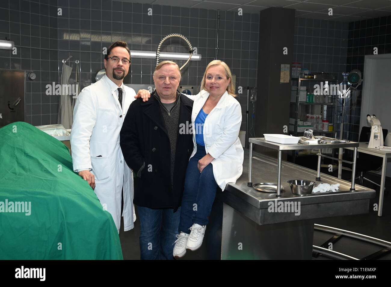 26. März 2019, Nordrhein-Westfalen, Köln: Die Schauspieler Jan Josef Liefers (L-R), Axel Prahl und Christine Urspruch stand in der Landschaft der gerichtlichen Medizin beim Fototermin am "Tatort Münster - Lakritz" (AT). Foto: Horst Galuschka/dpa Stockfoto