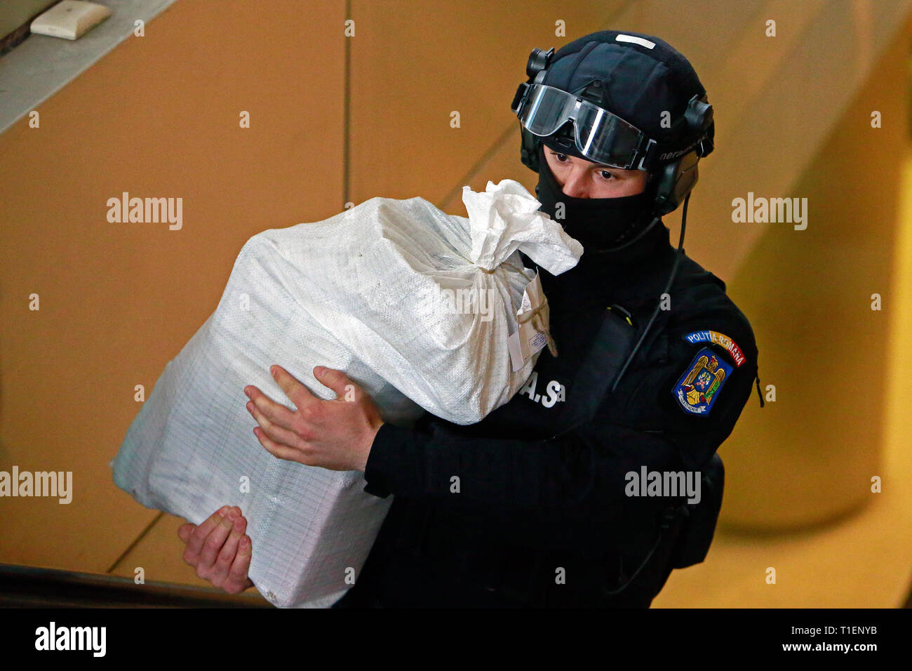 Bukarest, Rumänien. 26 Mär, 2019. Eine rumänische Polizei Agent trägt eine Tasche von Kokain im Gebäude der Direktion für die Untersuchung der organisierten Kriminalität und des Terrorismus (DIICOT) in Bukarest, Rumänien, 26. März 2019. Die rumänische Polizei über 1000 Kilogramm Kokain beschlagnahmt - hohe Reinheit im Donaudelta, mit einem schwarzmarktwert von rund 340 Millionen US-Dollar, des Landes gegen die organisierte Kriminalität Behörden angekündigt Dienstag. Credit: Cristian Cristel/Xinhua/Alamy leben Nachrichten Stockfoto