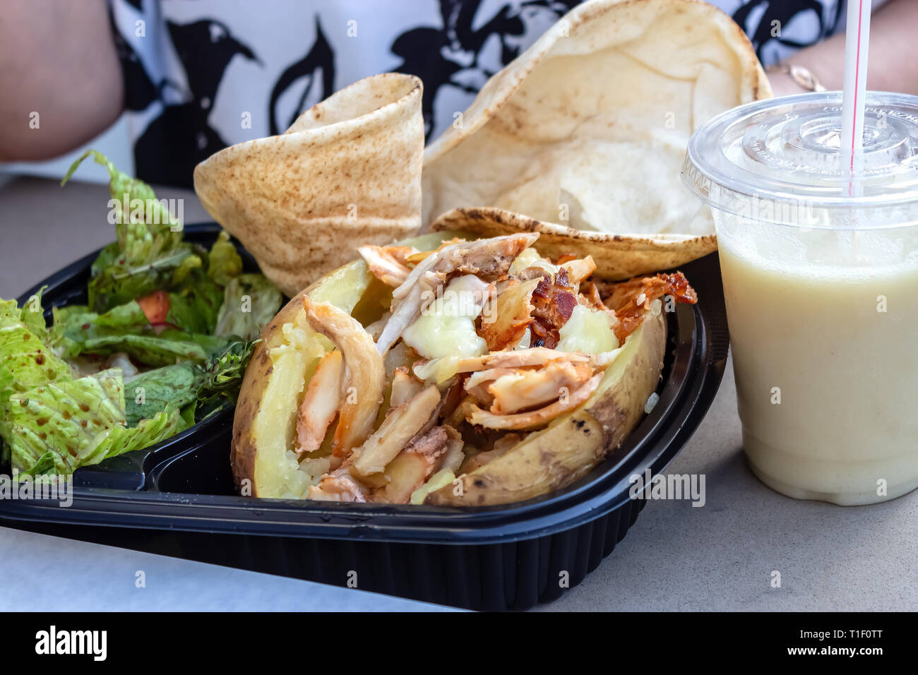 Mahlzeit mit doppelt gebackene Kartoffeln mit Huhn und Käse grüner Salat und Fladenbrot serviert. Gesund essen oder fast food Konzept. Stockfoto