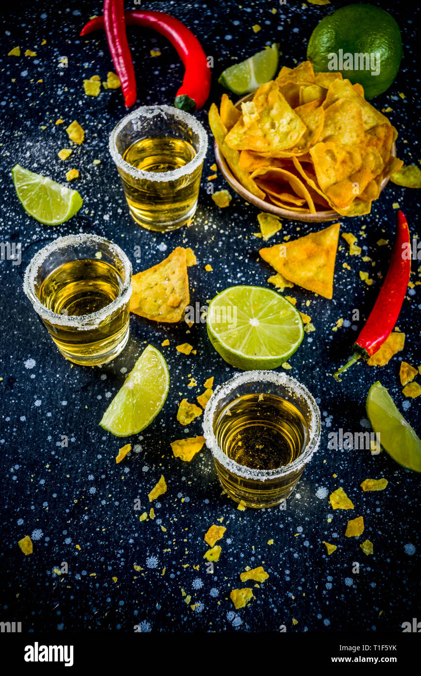 Cinco de Mayo feier Konzept. Getränke 5. Mai mexikanischen Partei - Margarita Cocktail, tequila Schüsse mit Kalk, hot chili peppers und Chips, dunkle Bac Stockfoto