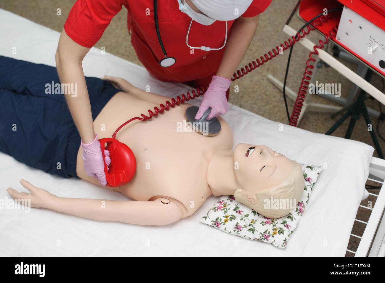 Arzt Mädchen defibrillieren Dummy Prüfung Ärzte, aber Notfall Reanimation. Konzept, Leben zu retten Stockfoto