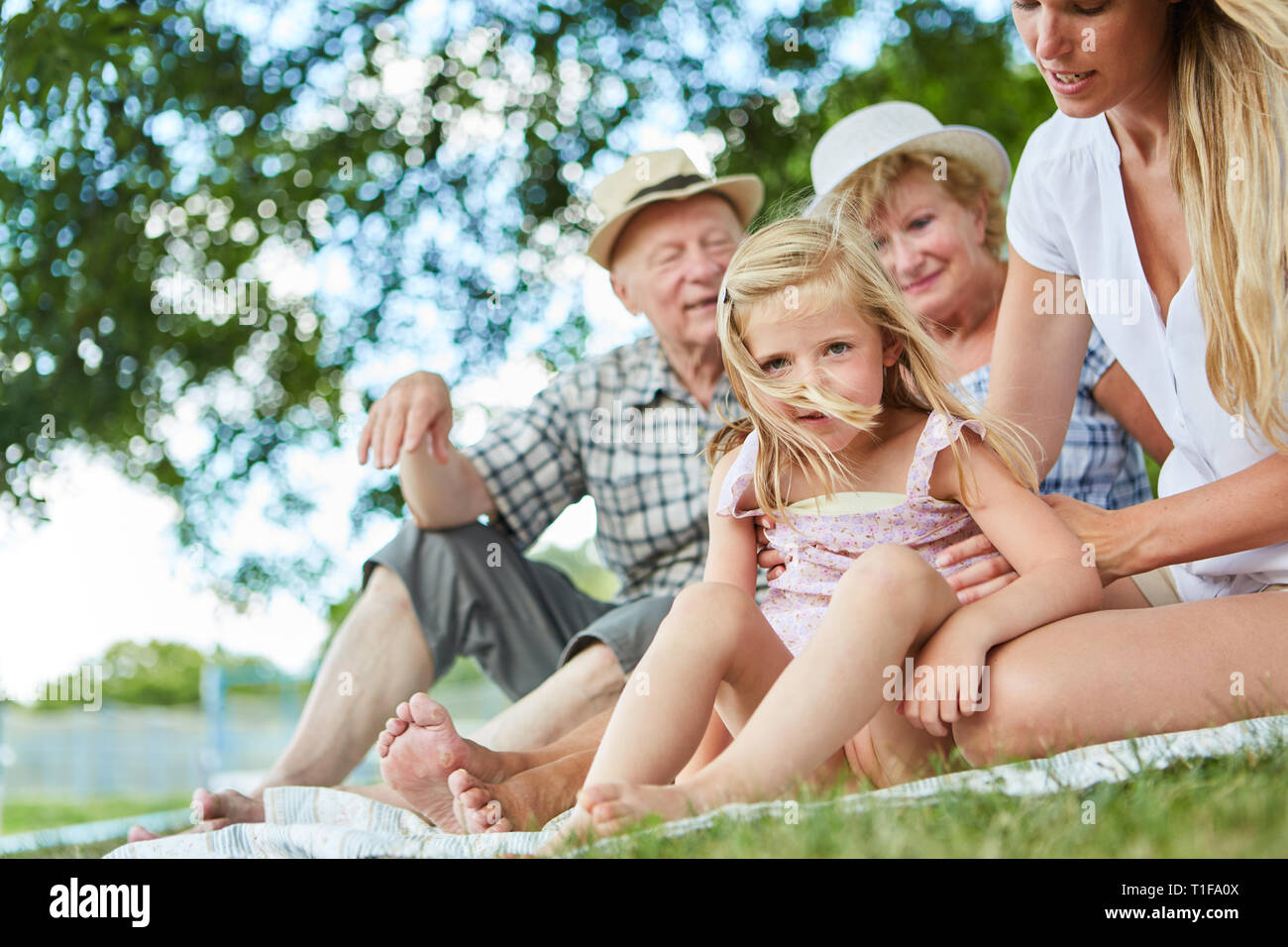 Erweiterte Familie im Garten oder auf einer Reise mit Kind und Großeltern im Sommer Stockfoto