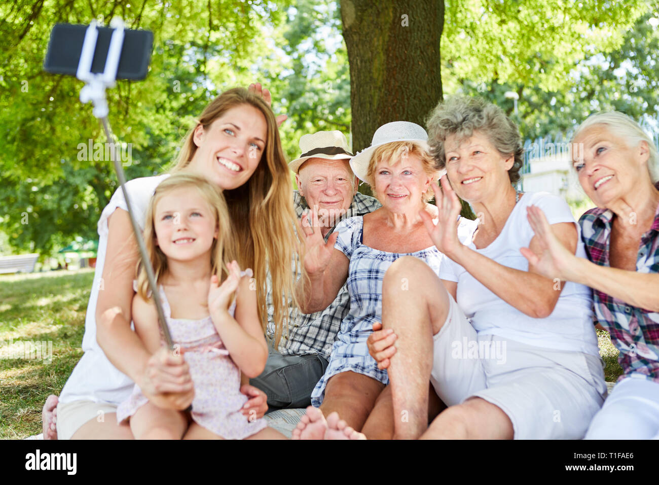 Erweiterte Familie mit Großeltern und Kid macht selfie mit selfie Stick im Garten Stockfoto