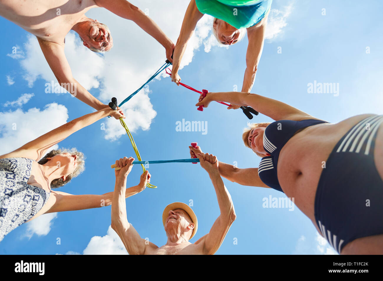 Aktive Senioren mit Seil springen während der Reha Ausbildung gemeinsam auf Urlaub in der Natur Stockfoto