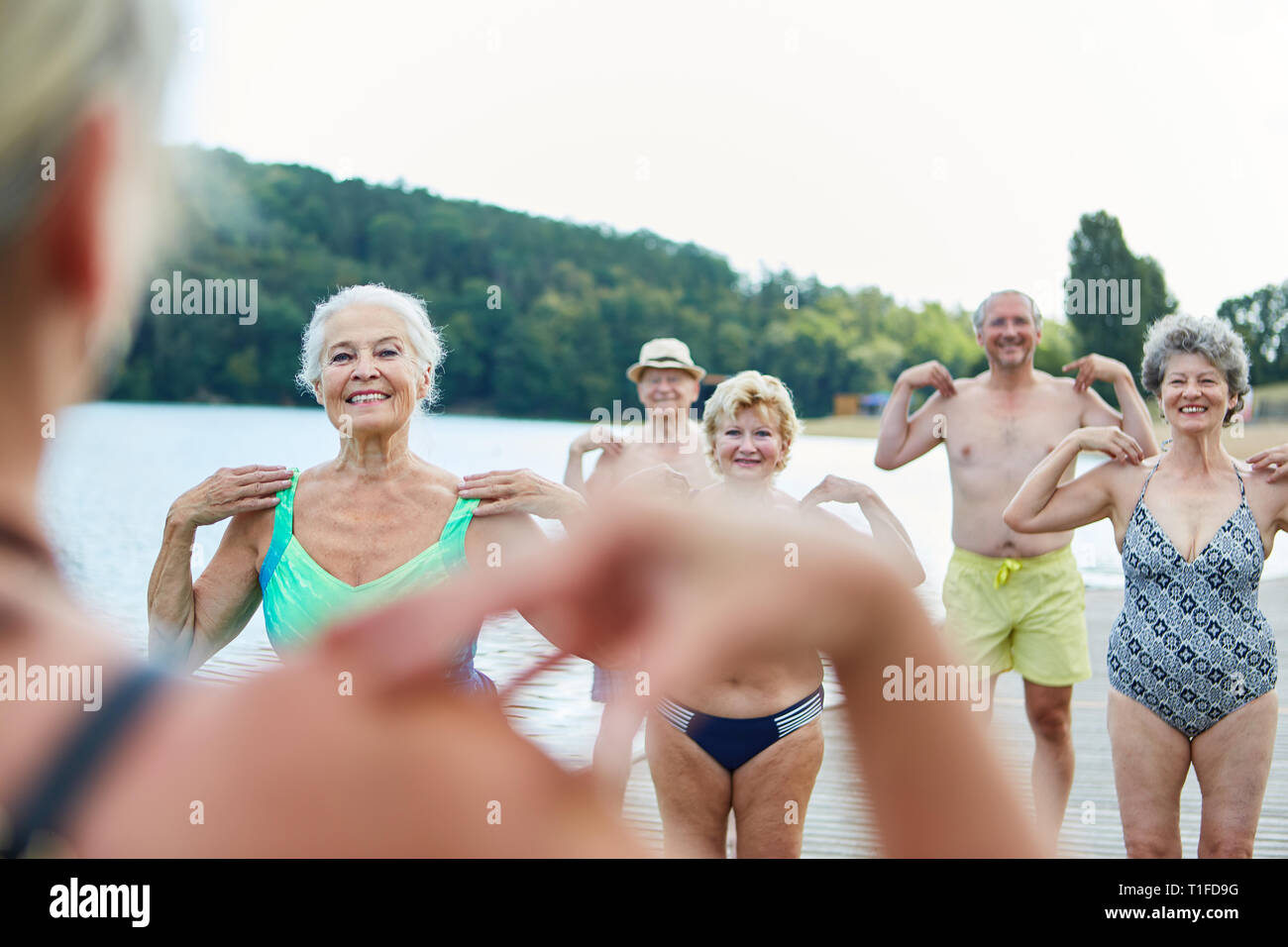 Senioren tun Reha Gymnastik Gemeinsam für die Gesundheit an der See im Sommer Stockfoto