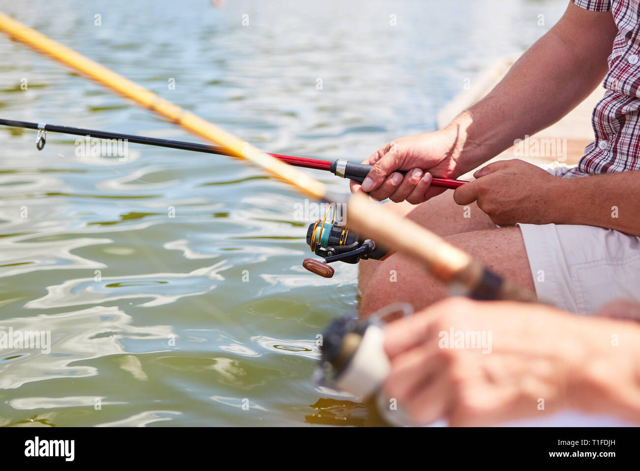 Angler gehen zusammen zum Fischen auf den See im Sommer als Zeichen der Geduld und Entspannung Stockfoto