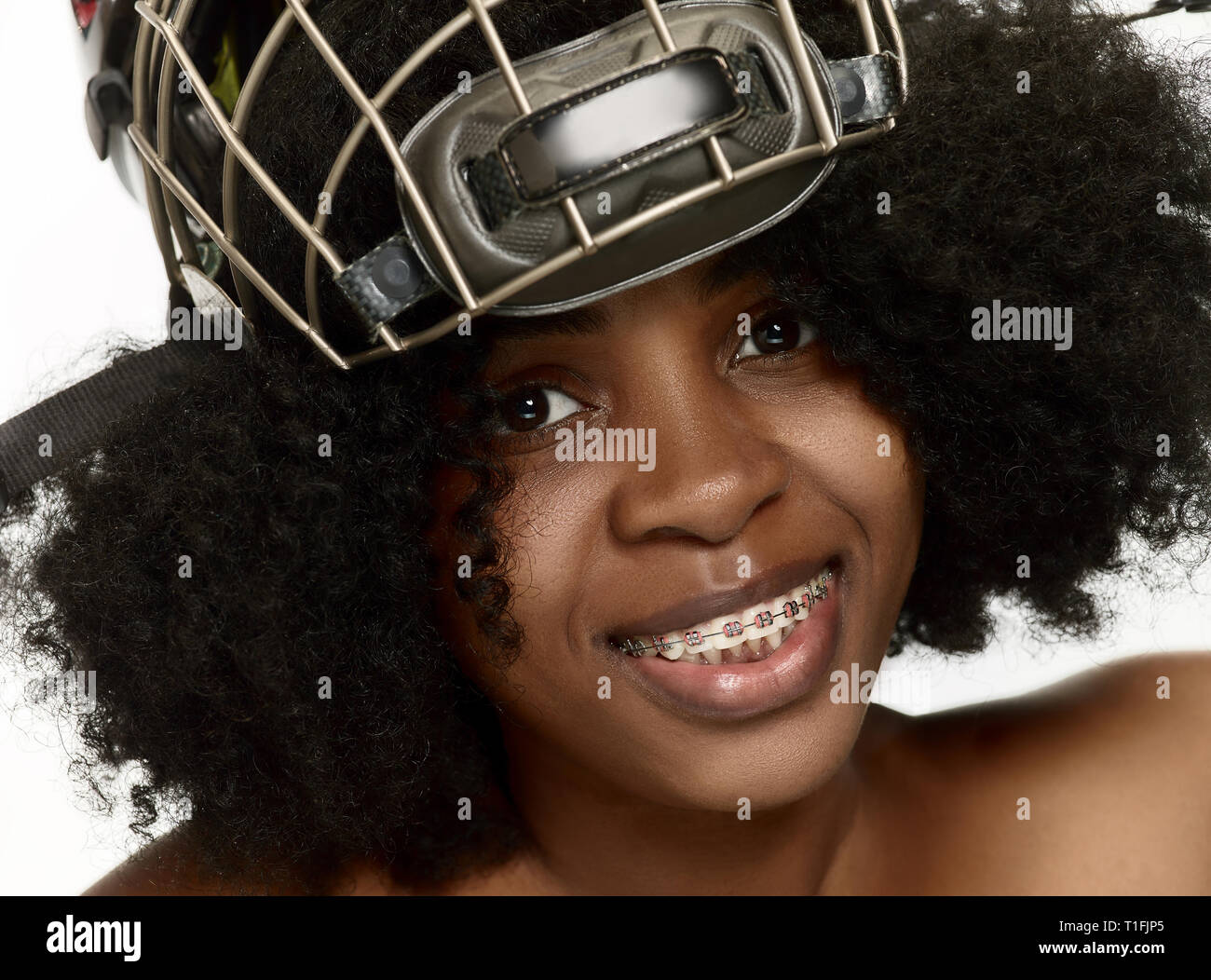 Weibliche hockey player schließen, Helm und Maske über weiße studio Hintergrund. Afrikanische amerikanische Modell Stockfoto