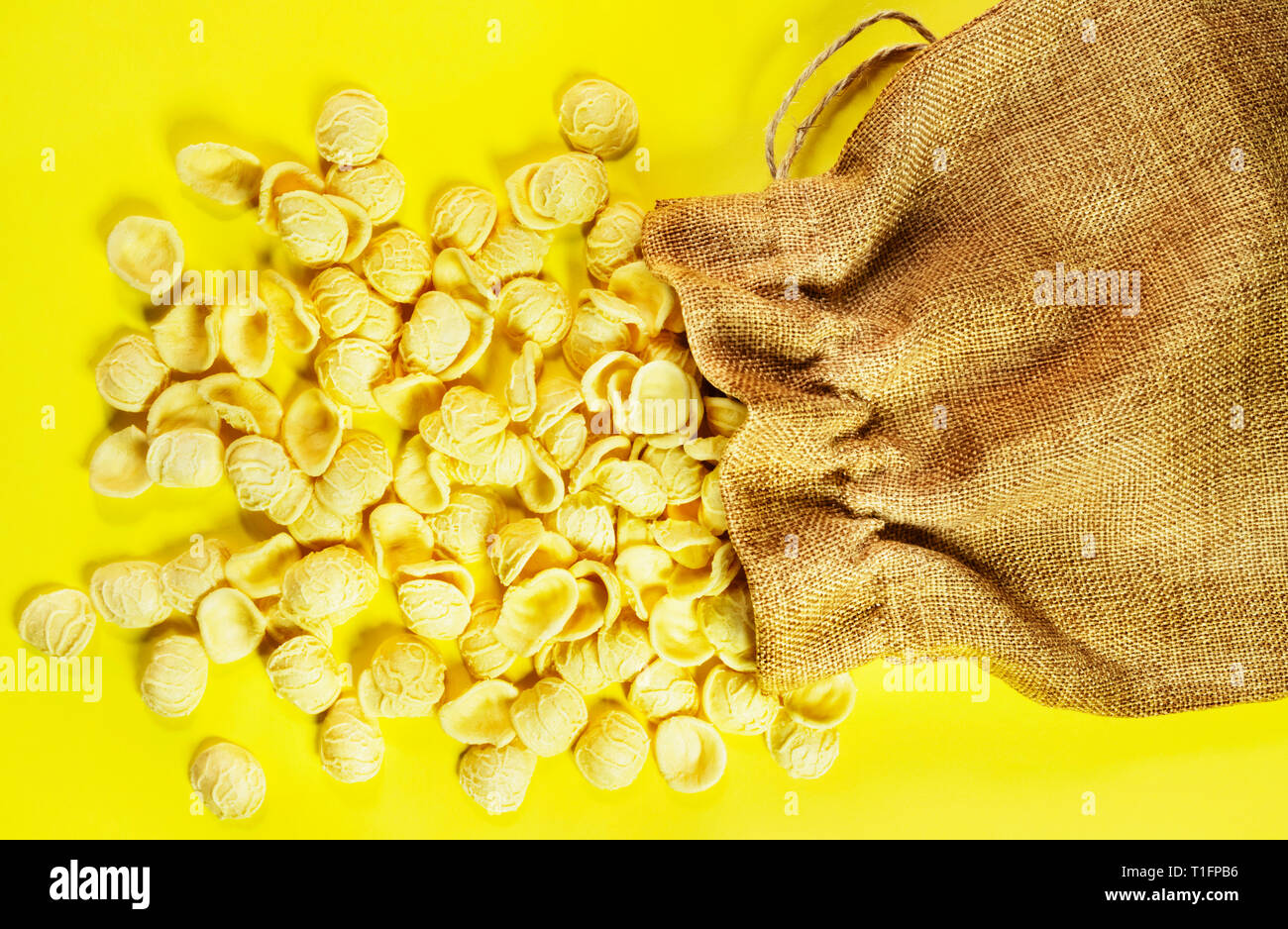 Pasta Orecchiette auf einem farbigen Hintergrund, eine kleine Ohrform Pasta in der Mitte dünner als am Rand und eine raue Oberfläche, die Nudeln aus o Stockfoto