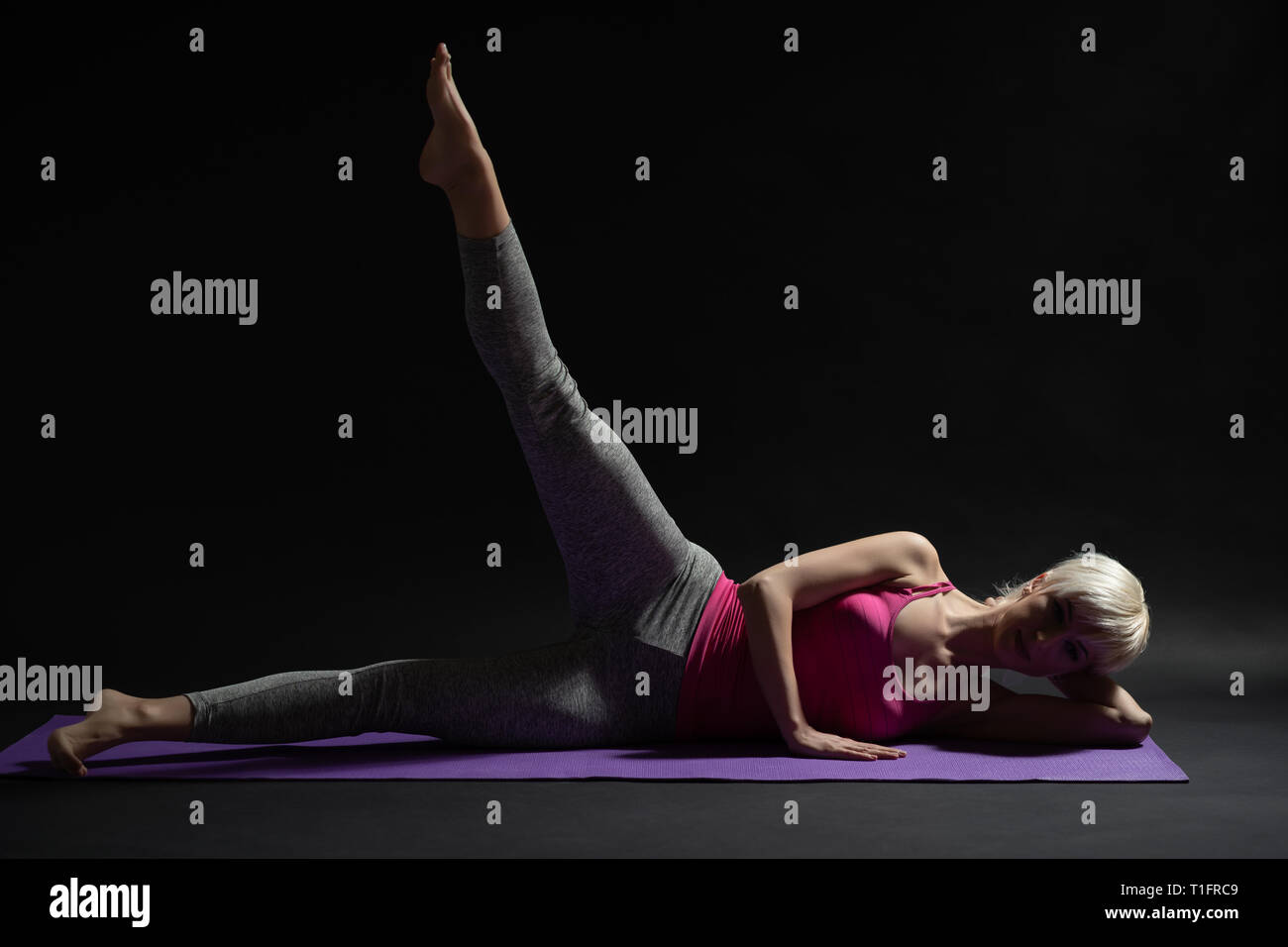 Frau Training Pilates. Seitlich gestrecktes Bein übung erhöhen. Stockfoto