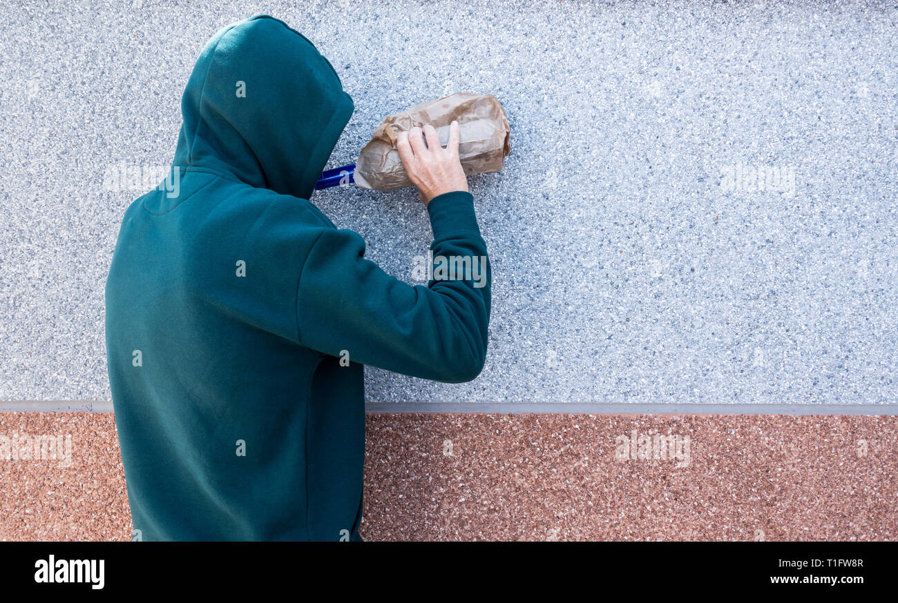 Mann mit Kapuze Alkohol im Freien. Psychische Gesundheit, Alkoholmissbrauch... Konzept. Stockfoto