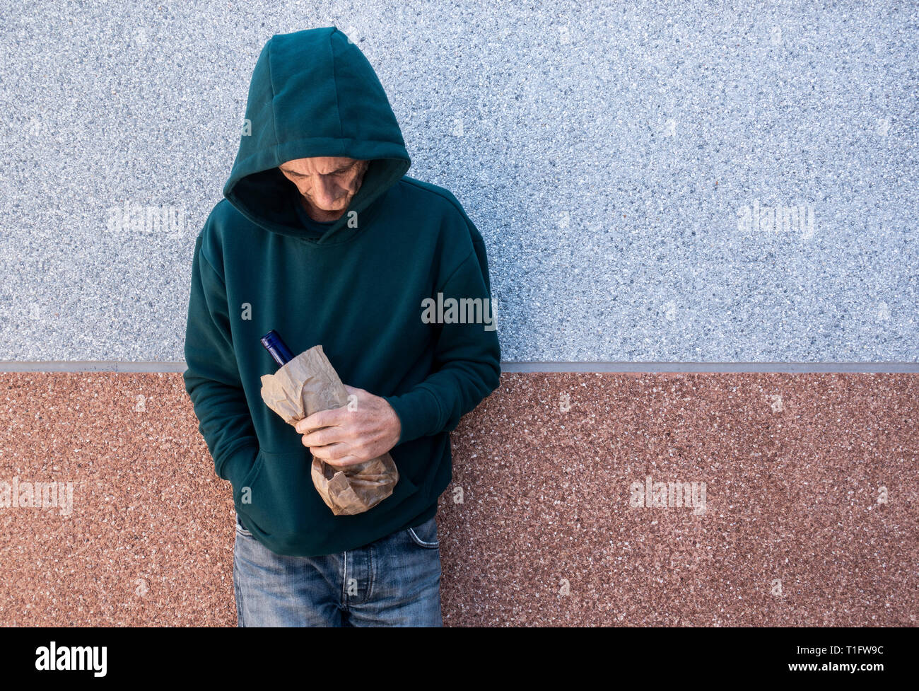 Mann mit Kapuze Alkohol im Freien. Psychische Gesundheit, Alkoholmissbrauch... Konzept. Stockfoto