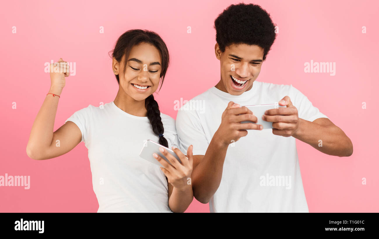 Teen paar Videospiele auf Smartphones Stockfoto