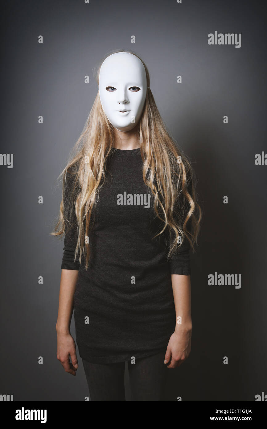 Geheimnisvolle Frau versteckt Gesicht und Identität hinter weißen Maske Stockfoto