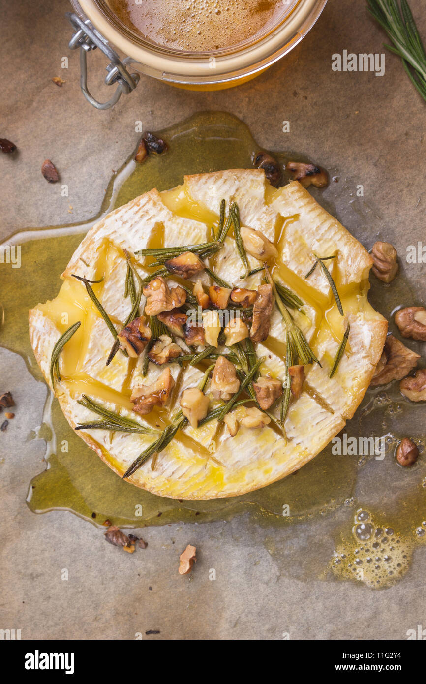 Köstliche Gebackene Camembert mit Honig, Nüssen, Kräutern und Birnen Stockfoto