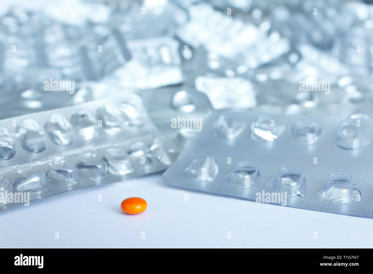 Eine einzige Pille vor vielen leeren blister Pakete auf weißem Hintergrund, Drogenmissbrauch Konzept Stockfoto