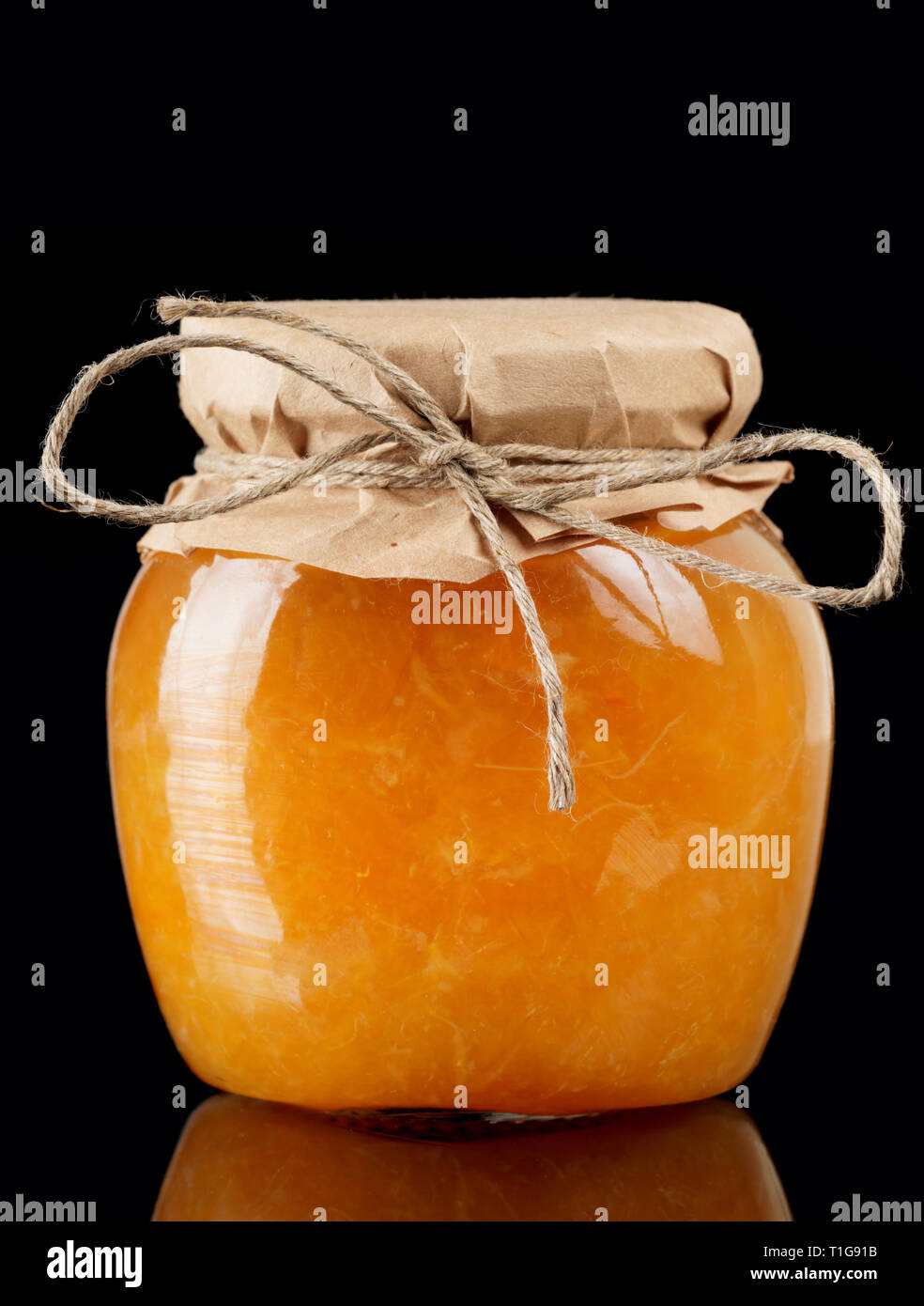 Orange Marmelade im Glas auf schwarzem Hintergrund Stockfoto