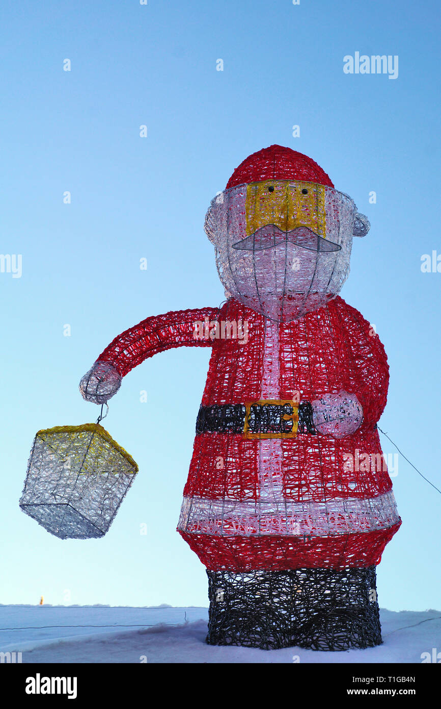 Weihnachtsmann mit Laterne in der Hand, blauer Himmel Stockfoto