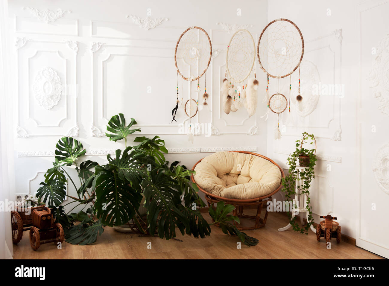 Inneneinrichtung mit tropischer Zimmerpflanzen monstera, Traumfnger und  Papasan Sessel Stockfotografie - Alamy