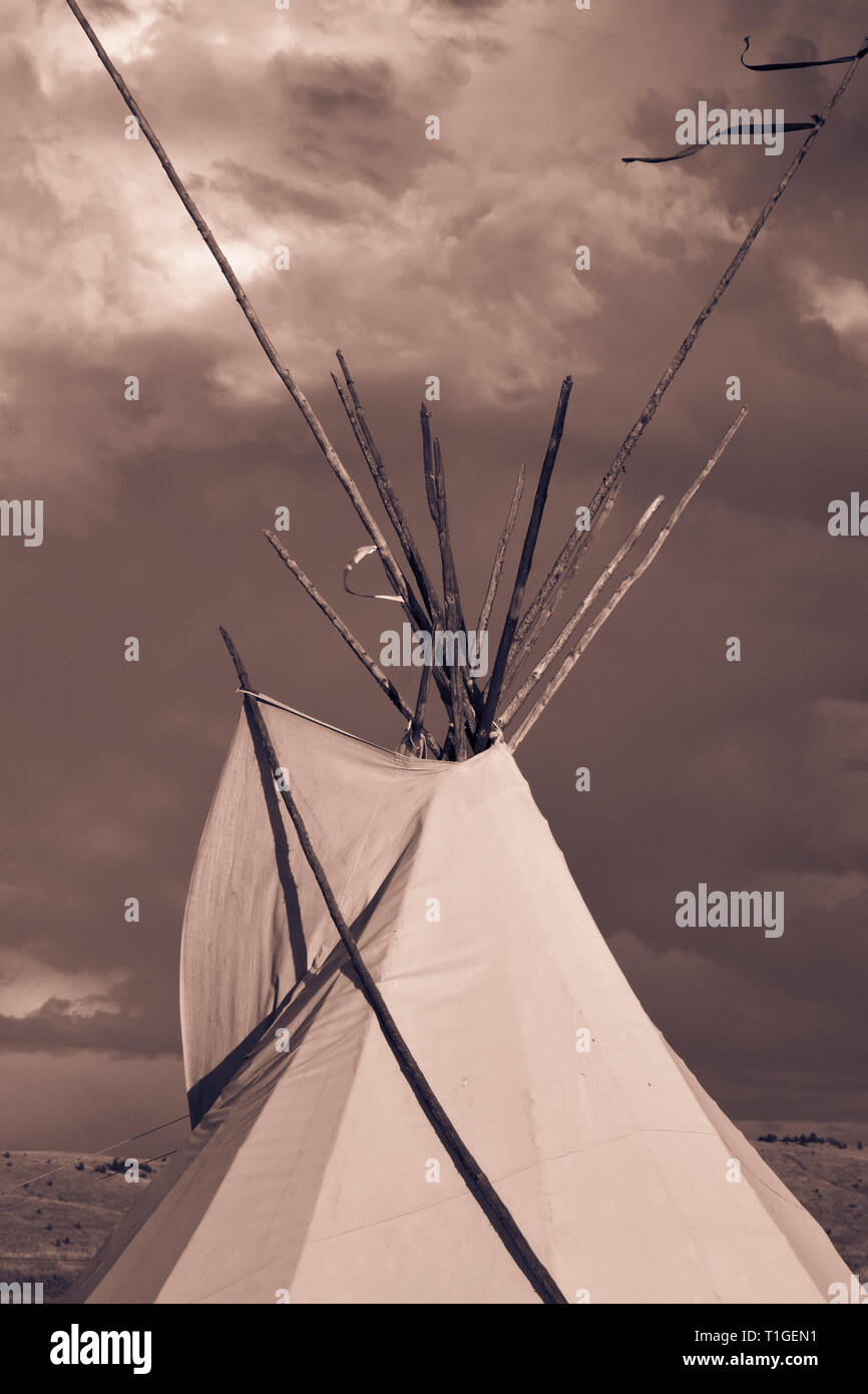 Eine Nahaufnahme bei Sonnenuntergang von der oberen Hälfte von einem Tipi mit dramatischen Himmel in der Western Plains in coppertoned Stockfoto